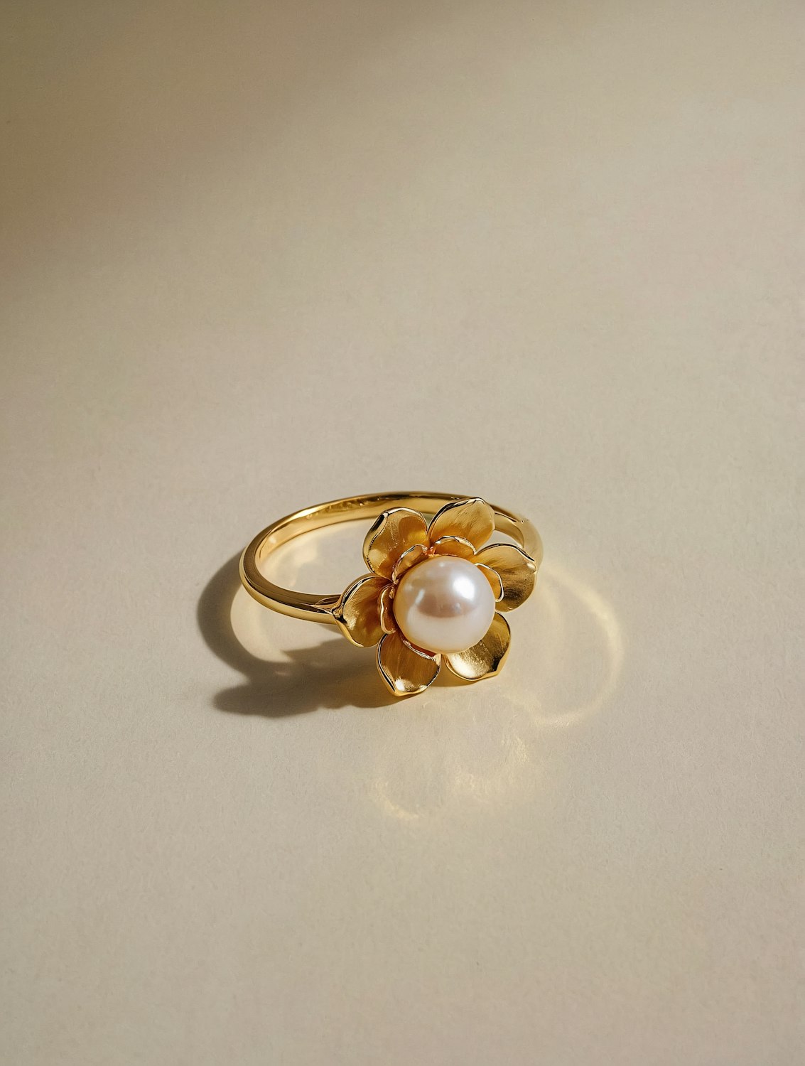 A gold and pearl ring resting on linen